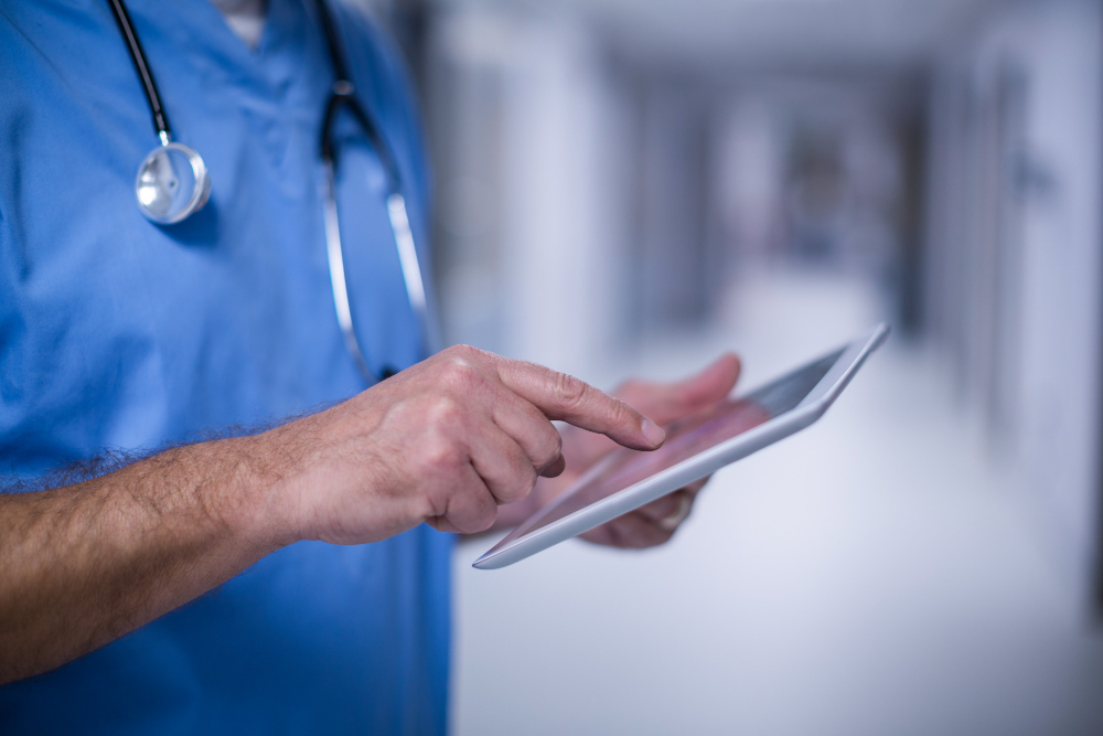 male surgeon using digital tablet operation room